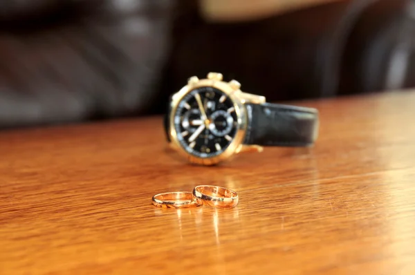 Bague de mariage et montres homme sur la table en bois — Photo