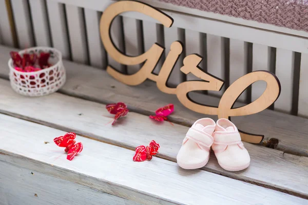 Doux fantaisie et coloré chaussures de bébé sur le bureau en bois avec fille — Photo