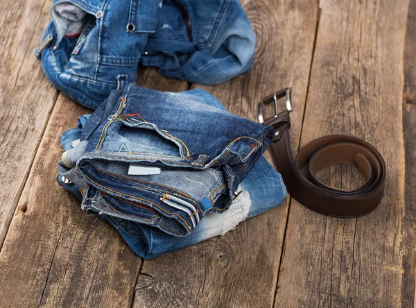 Pantalones vaqueros sucios y cinturón en suelo de madera —  Fotos de Stock