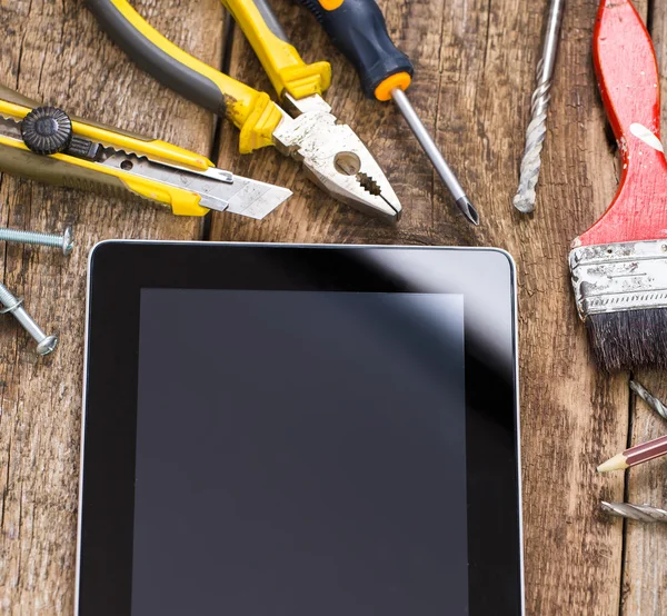 Diferentes ferramentas de equipamentos de construtor e tablet pc em tex de madeira — Fotografia de Stock