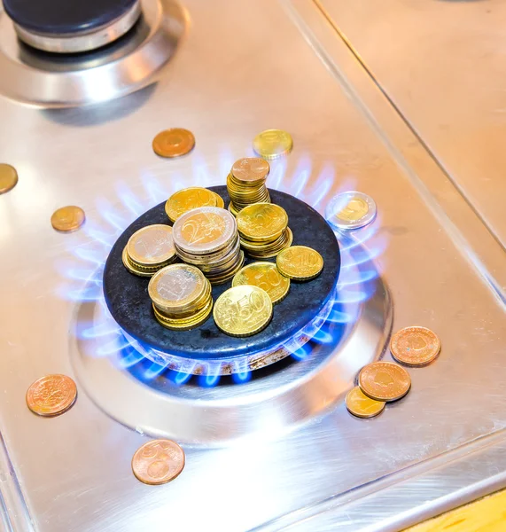 Flammes bleues de gaz naturel brûlant à partir d'un poêle à gaz avec des pièces en euros — Photo