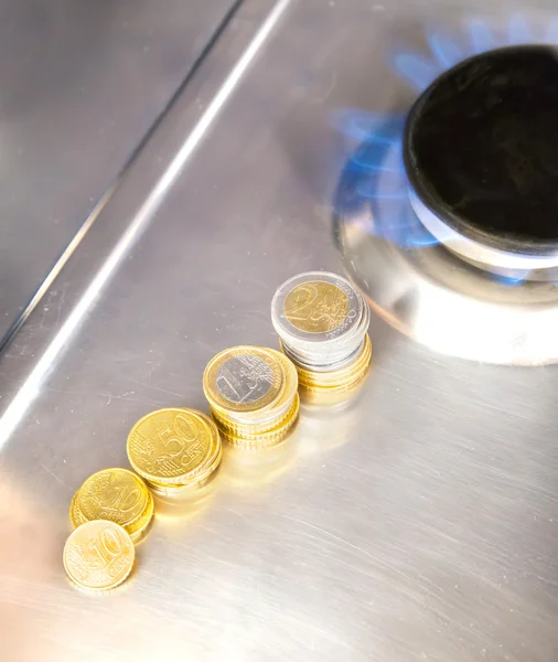 Blue flames of natural gas burning from a gas stove with euro coins — Stock Photo, Image