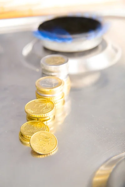 Chamas azuis de gás natural queimando de um fogão a gás com moedas de euro — Fotografia de Stock