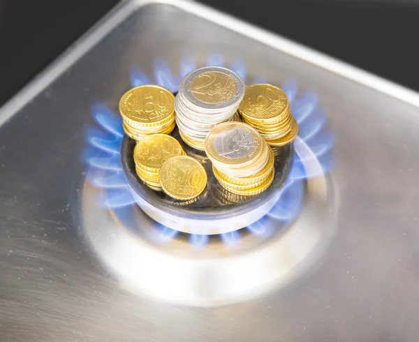 Llamas azules de gas natural quemadas de una estufa de gas con monedas en euros — Foto de Stock