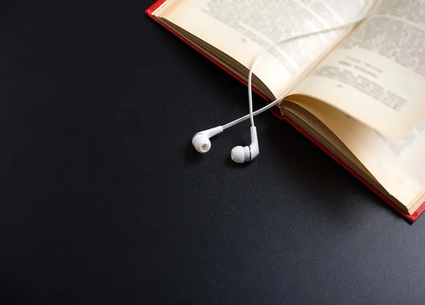 Book and ear plugs — Stock Photo, Image