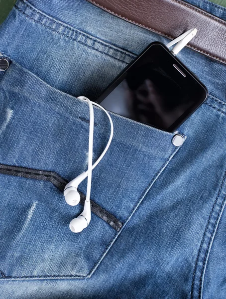 Leitor de MP3 e fones de ouvido saindo do bolso de jeans — Fotografia de Stock