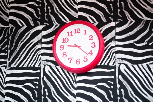 Reloj rojo mostrando 9: 20 en una pared de estilo cebra — Foto de Stock