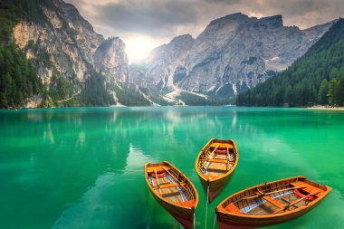 Stunning mountain lake with wooden boats in the Dolomites,Italy clipart