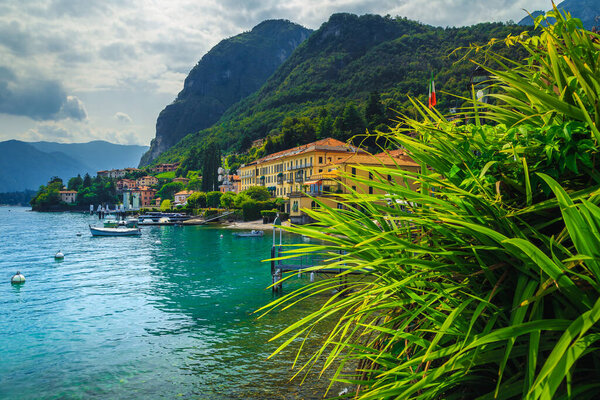 Picturesque waterfront with luxury holiday villas and anchored boats on the shore of the lake Como, Menaggio, Lombardy, Italy, Europe