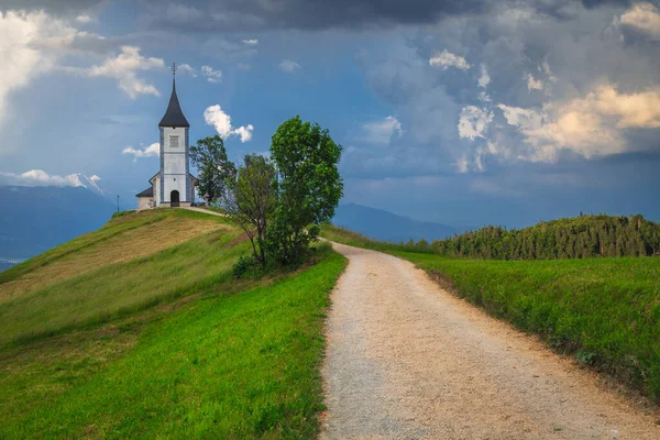 尾根上のかわいい教会と田舎の風景 背景に山 ジャムニク村 スロベニア ヨーロッパで曇りの風景と有名な高山聖プリモス教会 — ストック写真