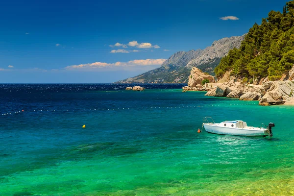 Beautiful bay and beach with motorboat, Brela, Dalmatia region, Croatia — стоковое фото