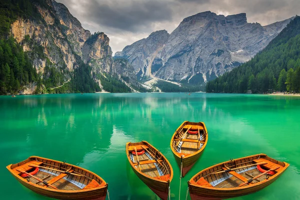 Güzel dağ gölü ile ahşap tekneler Dolomites, İtalya