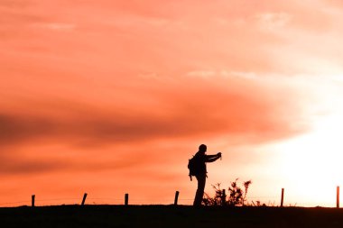 people taking photos in the meadow, sunset in spring season 