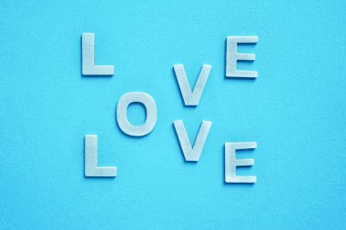    Sevgililer günü için mavi arka planda ahşap harflerle yazılmış aşk kelimesi.                             