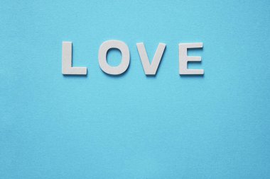    Sevgililer günü için mavi arka planda ahşap harflerle yazılmış aşk kelimesi.                             