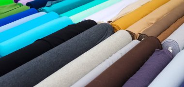 Kumaş pazarında bulunan kumaş ve kumaş örneklerine farklı renklerde yakından bakmak.