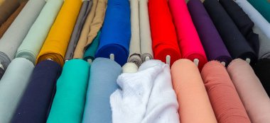 Kumaş pazarında bulunan kumaş ve kumaş örneklerine farklı renklerde yakından bakmak.