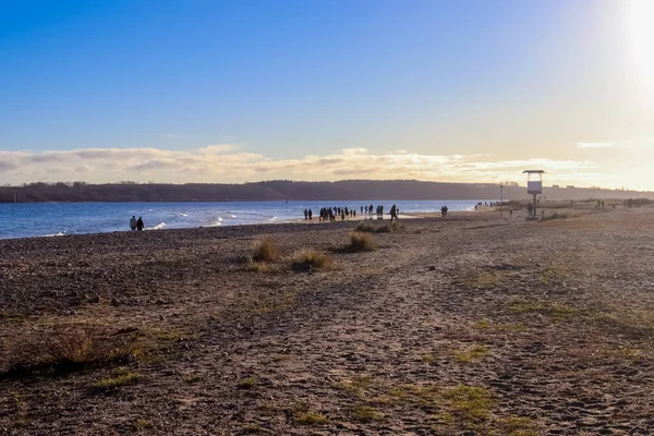 ドイツの日当たりの良いバルト海のビーチで散歩をしている人々のシルエット — ストック写真