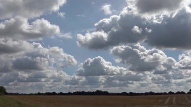 Güzel beyaz kabarık bulutların zaman akışı derin mavi bir yaz gökyüzünde rüzgarla hareket etti.
