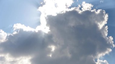 Derin mavi gökyüzünde parlayan beyaz kabarık bulutlar.