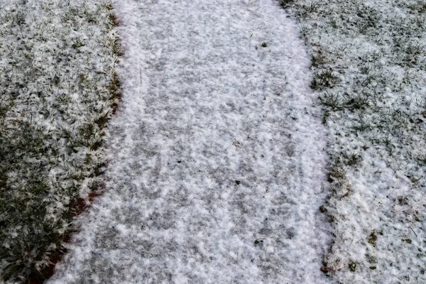 冬の古い石畳の道の白い雪の表面 — ストック写真