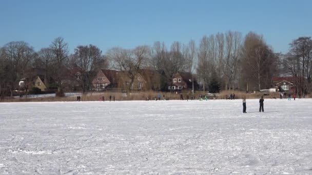 北ドイツの湖でアイススケートをしている人や子供たちがたくさんいます — ストック動画