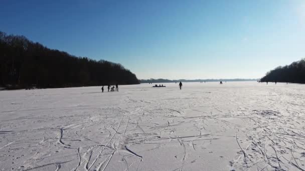 北ドイツの湖でアイススケートをしている人や子供たちがたくさんいます — ストック動画