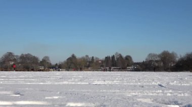 Birçok insan ve çocuk Kuzey Almanya 'da bir gölde buz pateni yapıyor..
