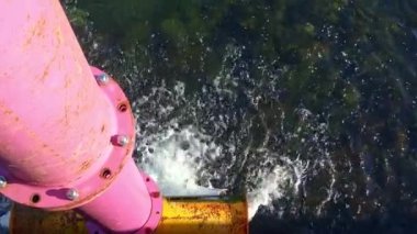 Su akıyor ve büyük pembe bir borudan Kiel limanına sıçrıyor.