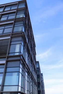 Almanya 'da Kiel' de bulunan pencerelere cam ve güneş ışığı yansıtan modern ofis cepheleri.