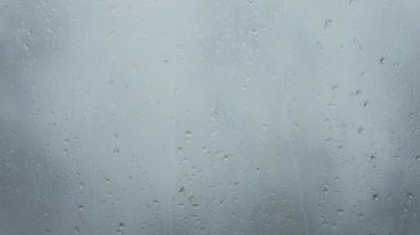 Yakın planda pencereden aşağı akan yağmur damlaları