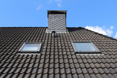 Siyah çatı kiremitleri ile Velux tarzı çatı penceresi