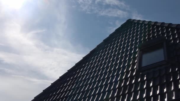 黒い瓦のベルクス様式の屋根窓のタイムラプ 青い空を通過する雲 — ストック動画