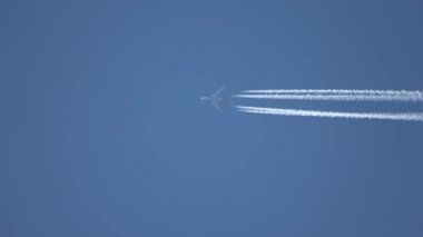 Jet uçakları gökyüzünde yükseklerde uçuyor açık mavi gökyüzünde kontrastlar bırakıyor.
