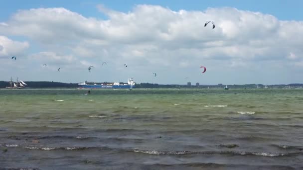 ドイツのラボエのビーチで大きな貨物船の前でカイトサーフィン活動 — ストック動画