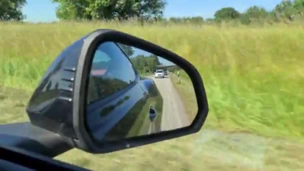 Zicht Zijspiegel Van Een Zwarte Sportwagen Tijdens Het Rijden — Stockvideo