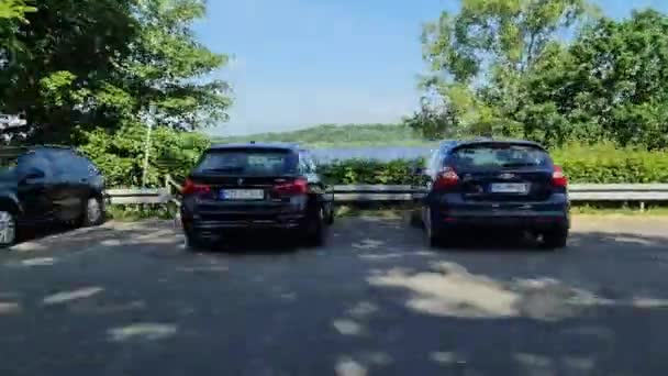 湖と駐車スペースを見ながら高速運転車のサイドウィンドウからの眺め — ストック動画