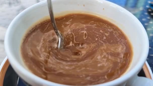 Super cámara lenta de leche revolviendo en una taza de café. — Vídeo de stock