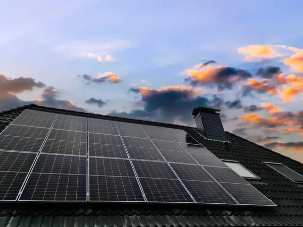 Siyah çatı kiremitleri ve bazı güneş panelleri ile Velux tarzı çatı penceresi