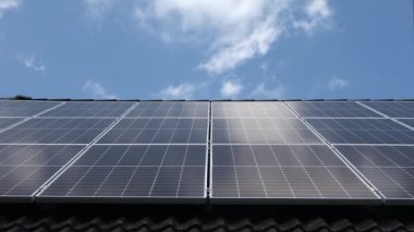 Siyah kiremit çatısındaki güneş panelleri üzerindeki bulut yansımalarının zaman akışı