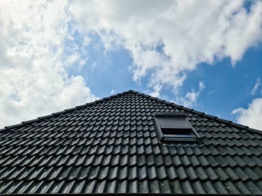 Siyah çatı kiremitleri ile Velux tarzı çatı penceresini aç
