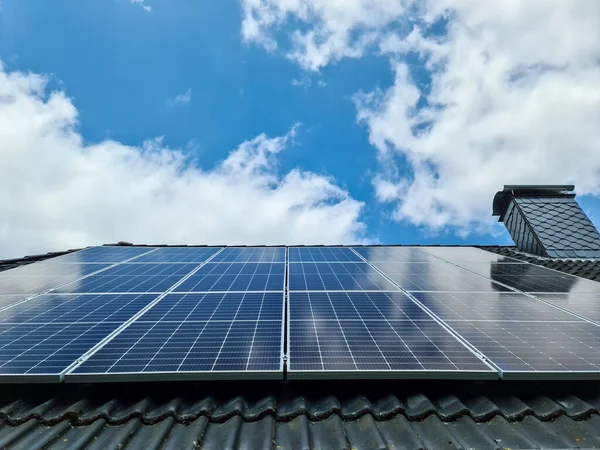 在住宅屋顶上生产清洁能源的太阳能电池板 — 图库照片