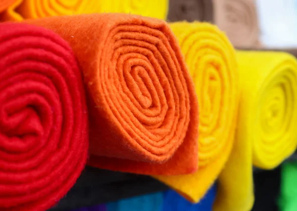 Detailed close up view on samples of cloth and fabrics in different colors found at a fabrics market.
