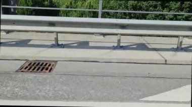 Sürücü arabasının yan camından geçen bir yolun asfaltına bakın.