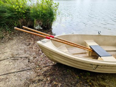 Güneşli bir günde bir gölün kıyısında uzanan kayık.