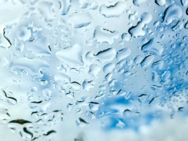 Yakın planda pencereden aşağı akan yağmur damlaları