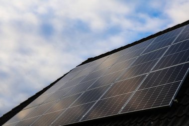 Solar panels installed on a residential roof, converting sunlight into clean, renewable electricity under a cloudy sky