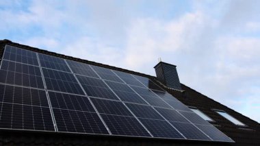Modern solar panels on a tiled roof generating clean, renewable energy from the sun. Sustainable technology for a residential home
