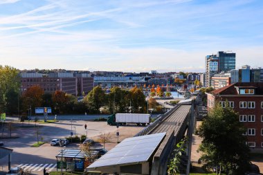 Kiel, Almanya - 17. Ekim 2025: Açık bir gökyüzü altında bir liman, binalar ve güneş panelleri gösteren şehir manzarası