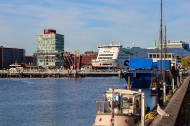 Kiel, Almanya - 17. Ekim 2025: Gemiler modern bir bina ve açık mavi gökyüzü ile limana yanaştı